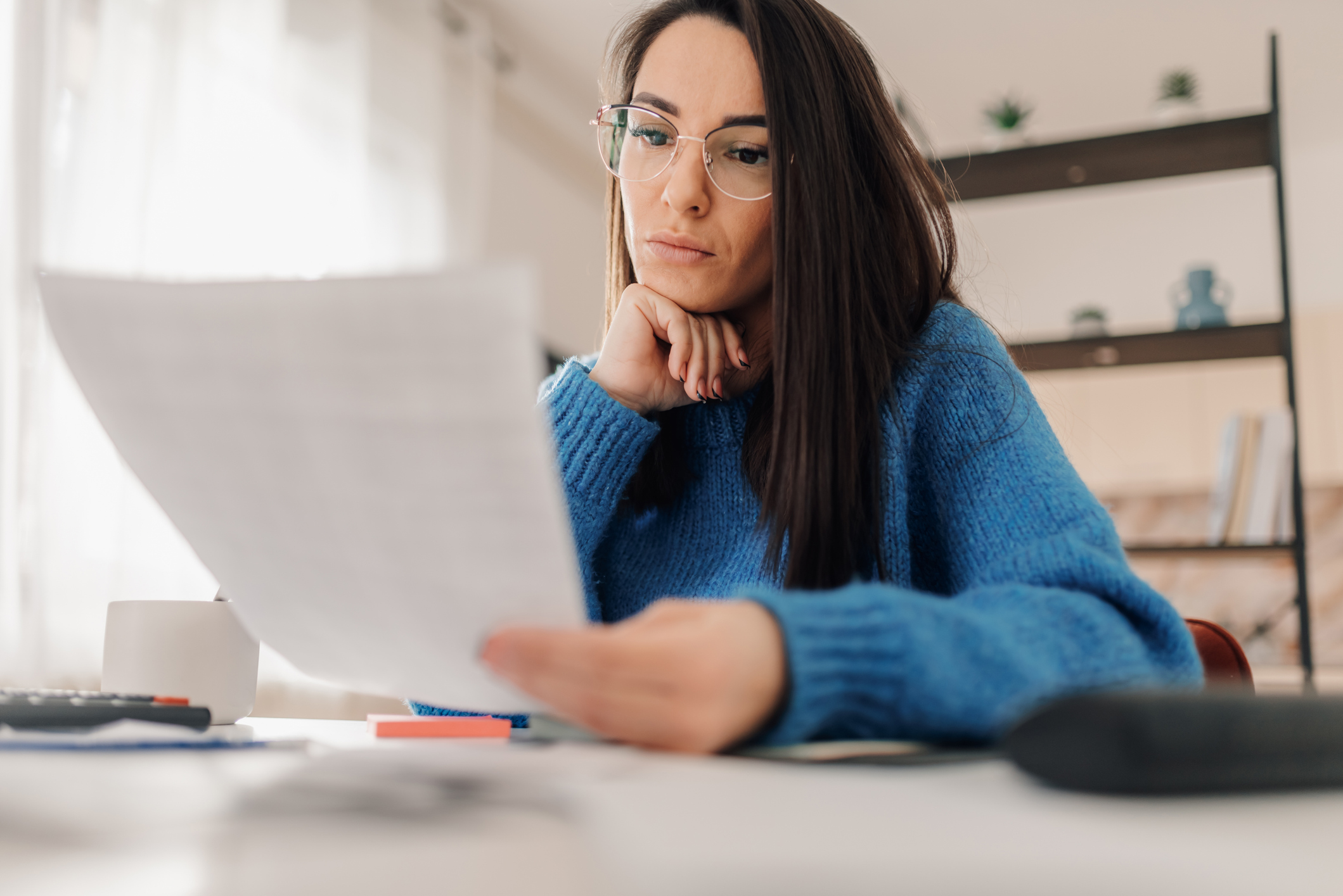 Business owner reviewing a budget and pricing documents at a desk — social media management cost